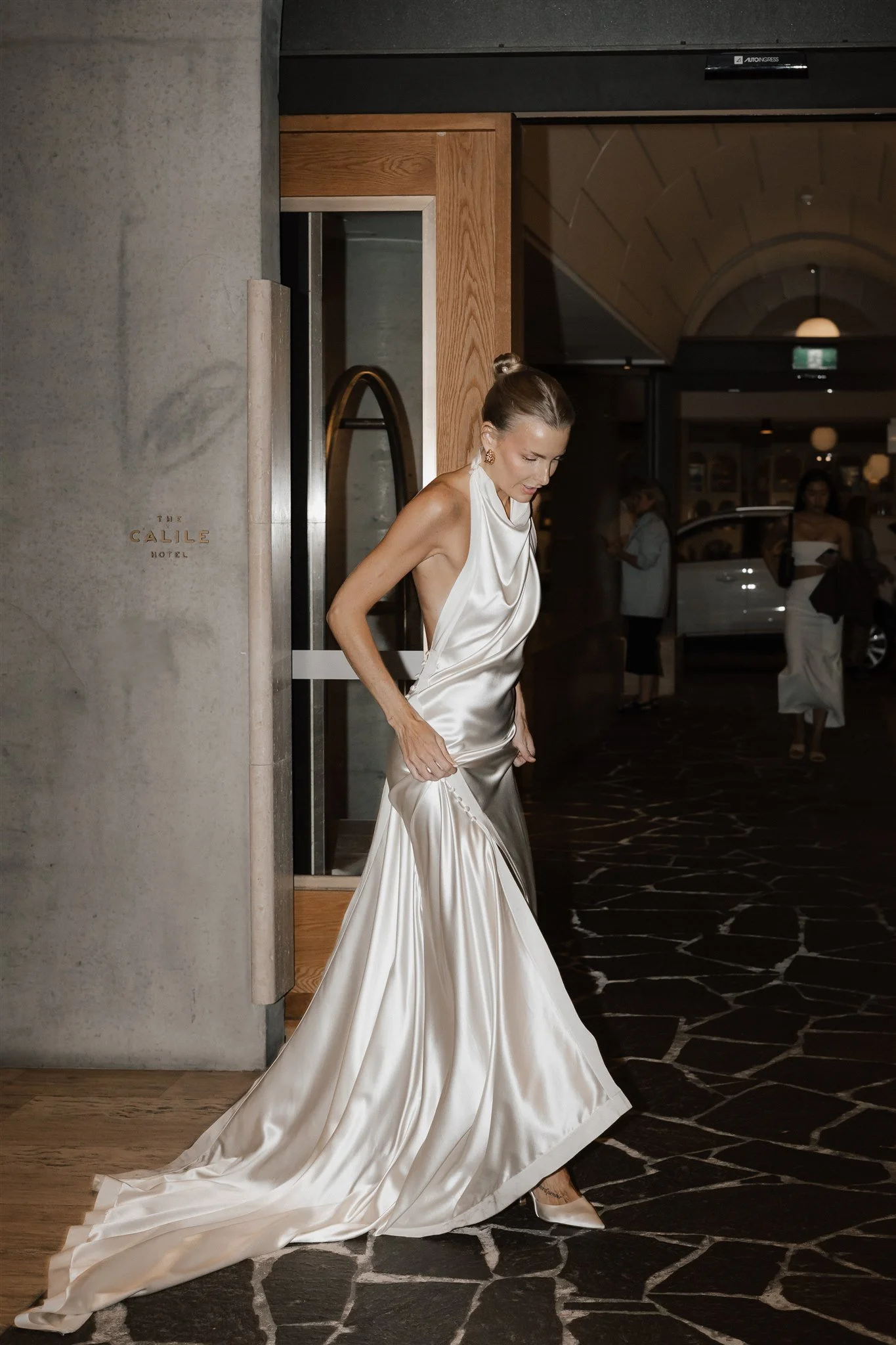 A bride stepping through a hotel doorway, photographed by Bulb Creative.