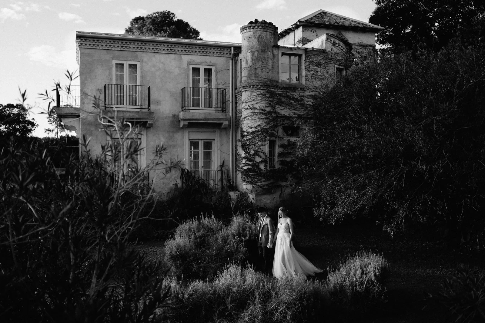 A couple holding hands in a garden during a Byron Bay elopement created by The Elopement Collective.